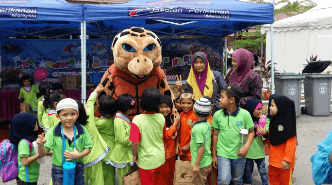 Children meeting the turtle mascot with Jabatan Perikanan